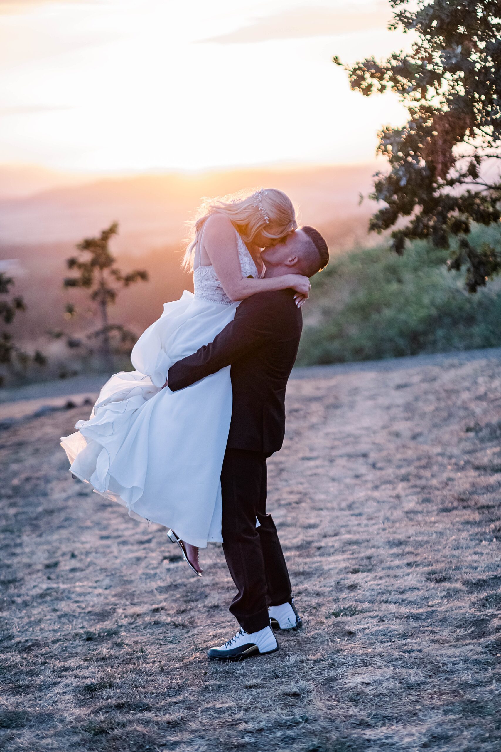 romantic wedding portraits of newlyweds kissing at sunset