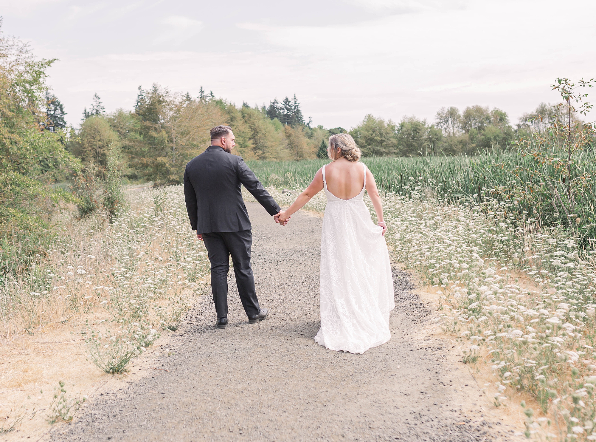 bride and groom hold hands as they walk together