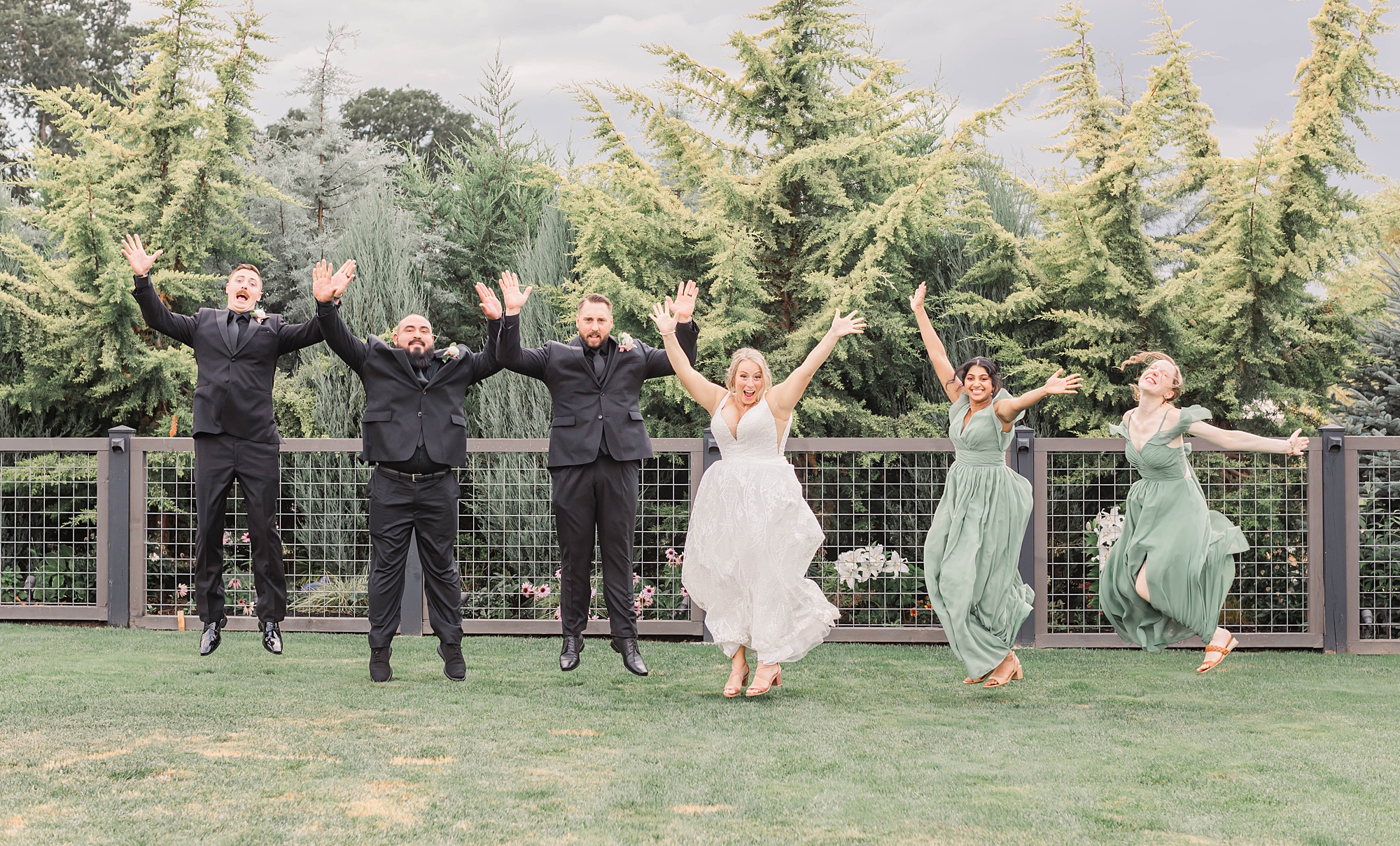 fun wedding party portraits of group jumping in the air