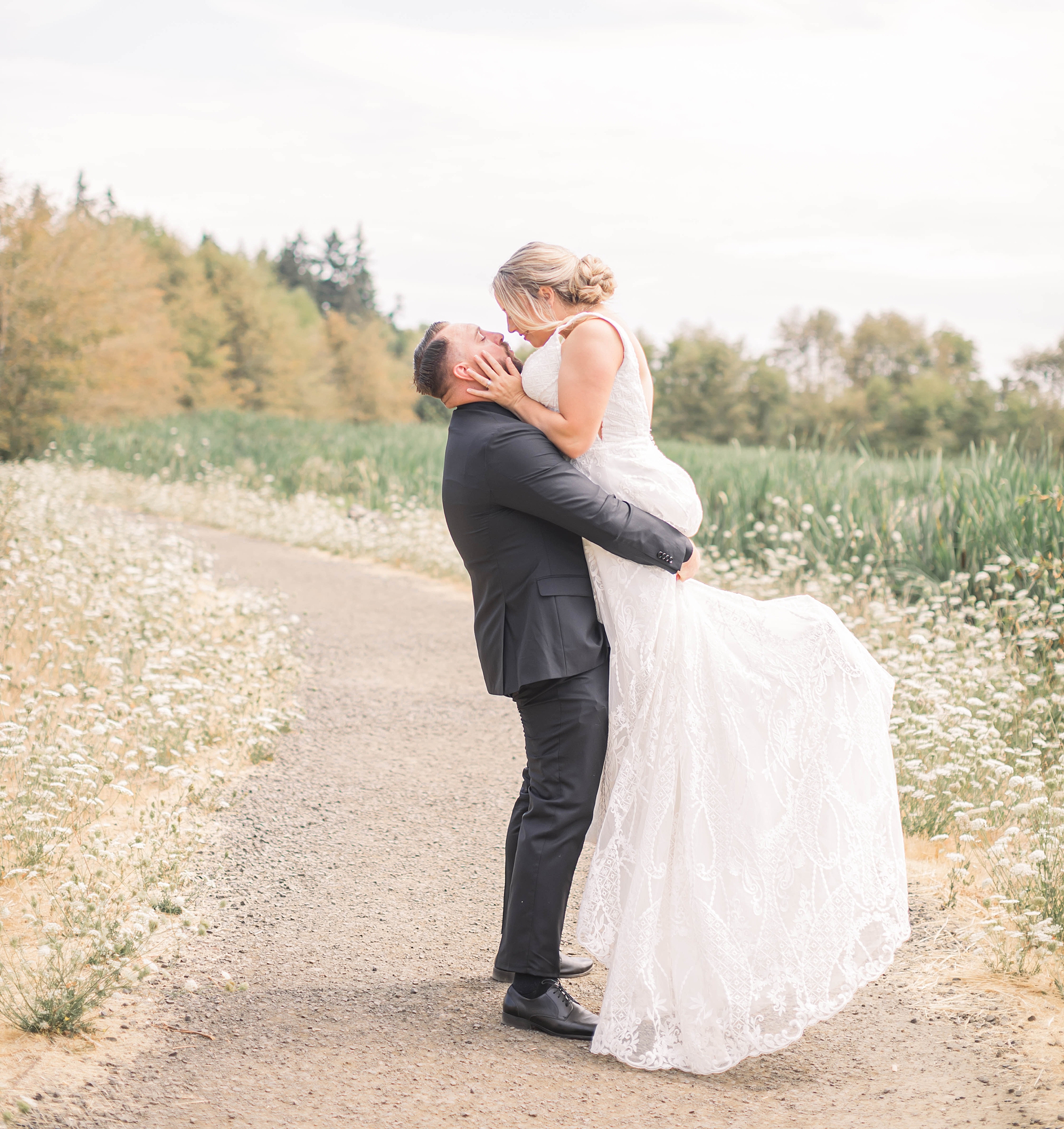 groom lifts his bride as they kiss in romantic wedding portraits 