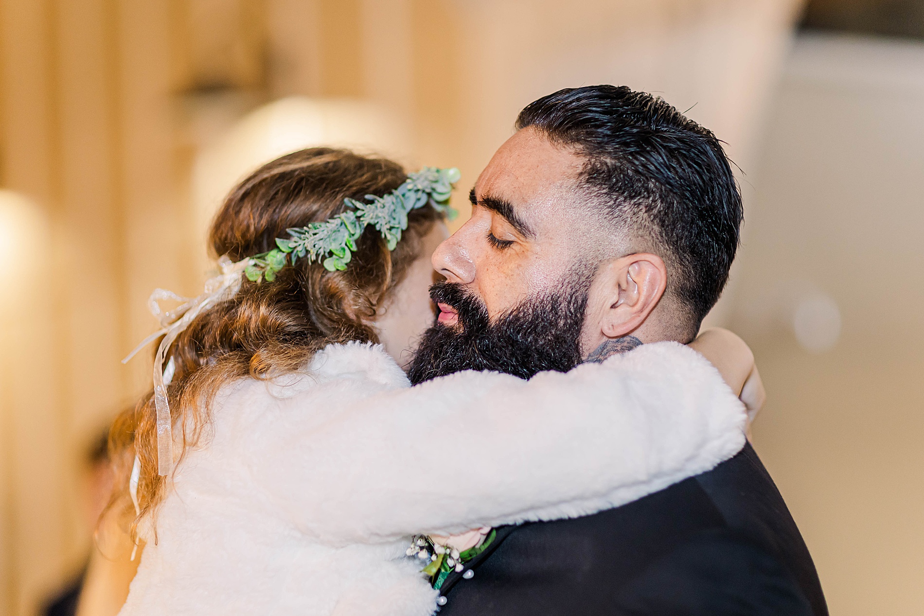 groom hugs little girl in wedding